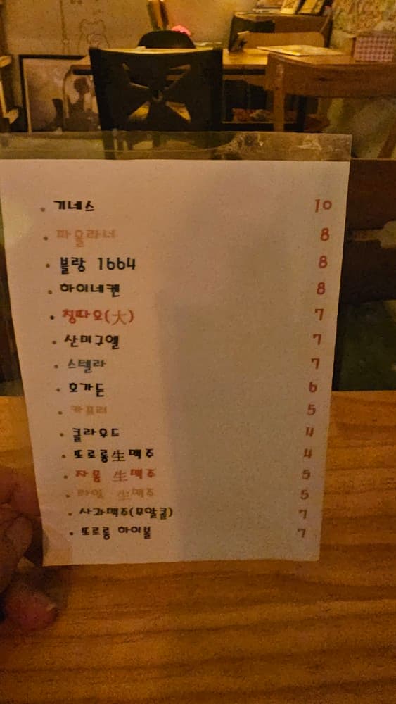 또로롱호프의 맥주와 하이볼 메뉴판. 아늑한 나무 테이블과 조명이 어우러져 혼술하기 좋은 정겨운 호프집 내부 모습입니다.