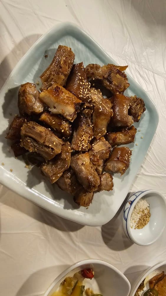 두근두근포차의 깨가 뿌려진 노릇한 고기 구이와 소금. 혼술 안주로도 좋은 동래구 포차의 먹음직스러운 메뉴.