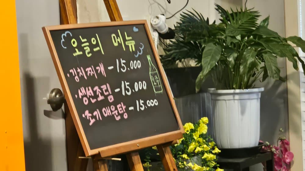 두근두근포차 오늘의 메뉴 칠판, 김치찌개 등 혼술하기 좋은 안주 구성과 아늑한 화초 인테리어
