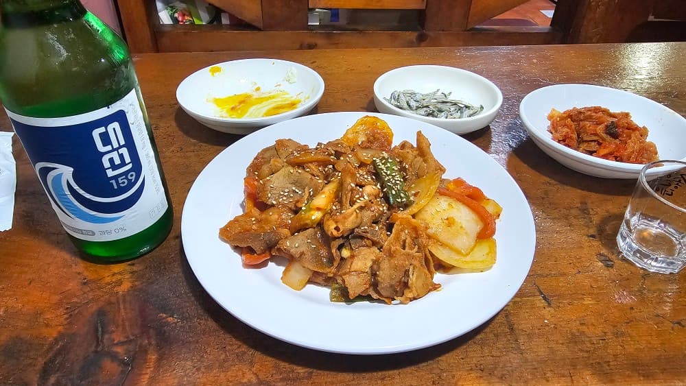 부산 동래구 오딧세이 포차, 제육볶음과 대선 소주가 차려진 혼술하기 좋은 아늑한 나무 테이블