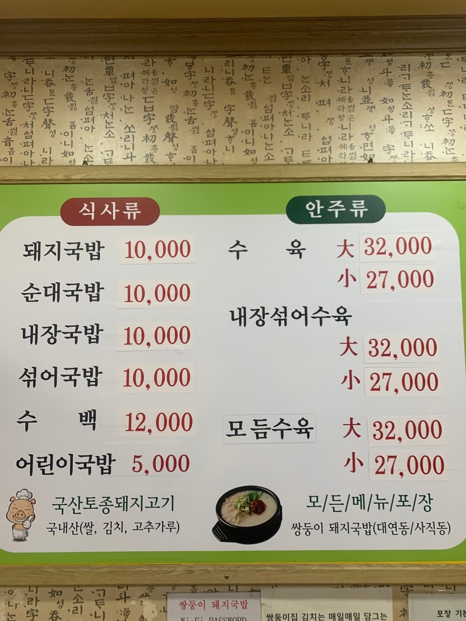 한글 고서체 무늬 벽면에 부착된 국밥과 수육 메뉴판. 1인 식사류와 안주류로 구분된 다양한 메뉴와 가격 정보가 나열된 모습