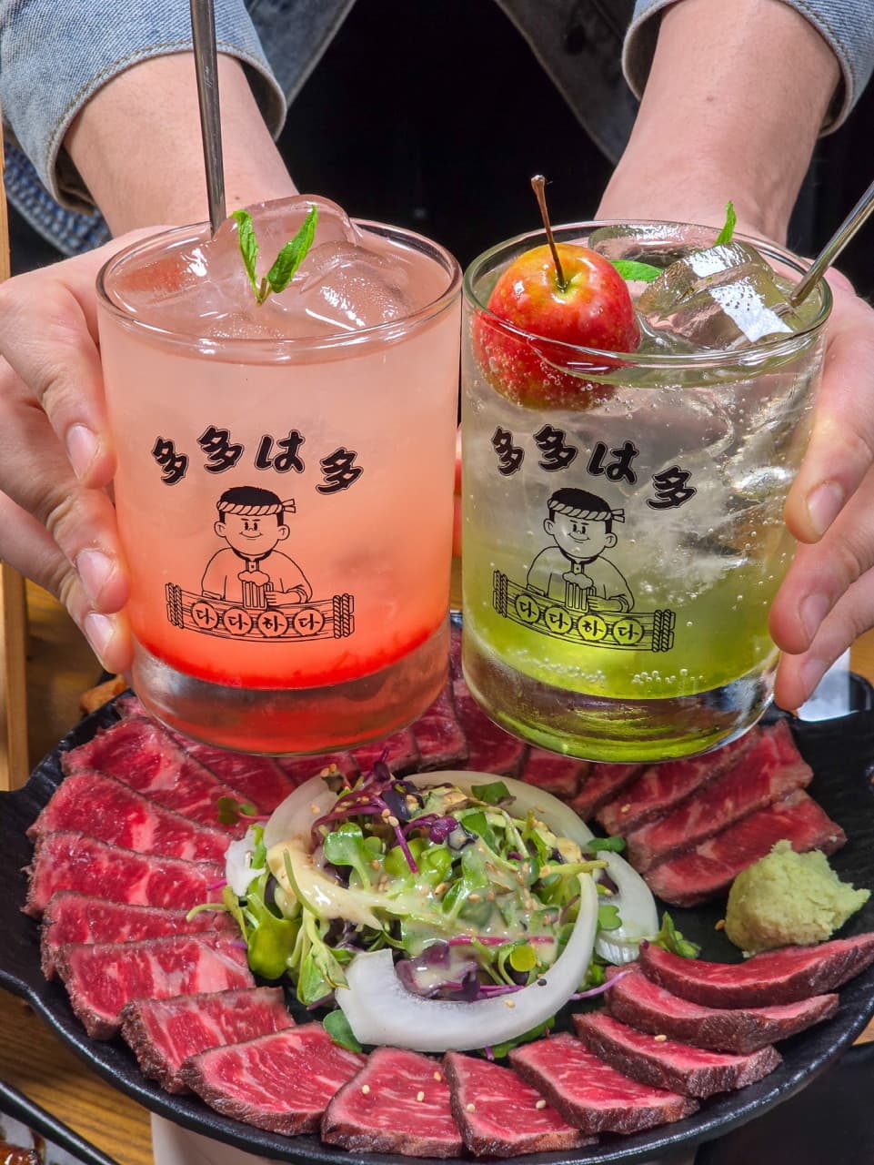 얼음과 민트가 담긴 두 종류의 하이볼 잔 아래 선홍빛 소고기 타다끼와 채소 샐러드가 놓인 안주 접시