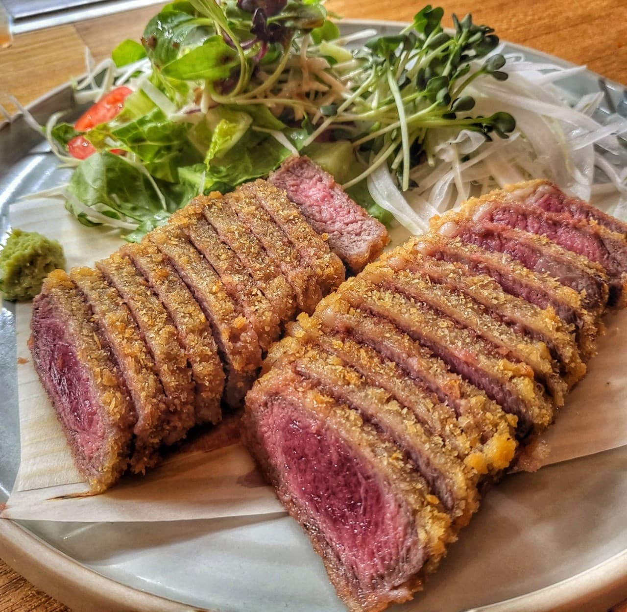 서울특별시 마포구 호요 홍대 이자카야 혼술 다찌석. 바삭한 튀김옷과 선홍빛 소고기 단면의 규카츠가 샐러드와 함께 나무 테이블 위 접시에 정갈하게 차려진 1인 메뉴 구성.