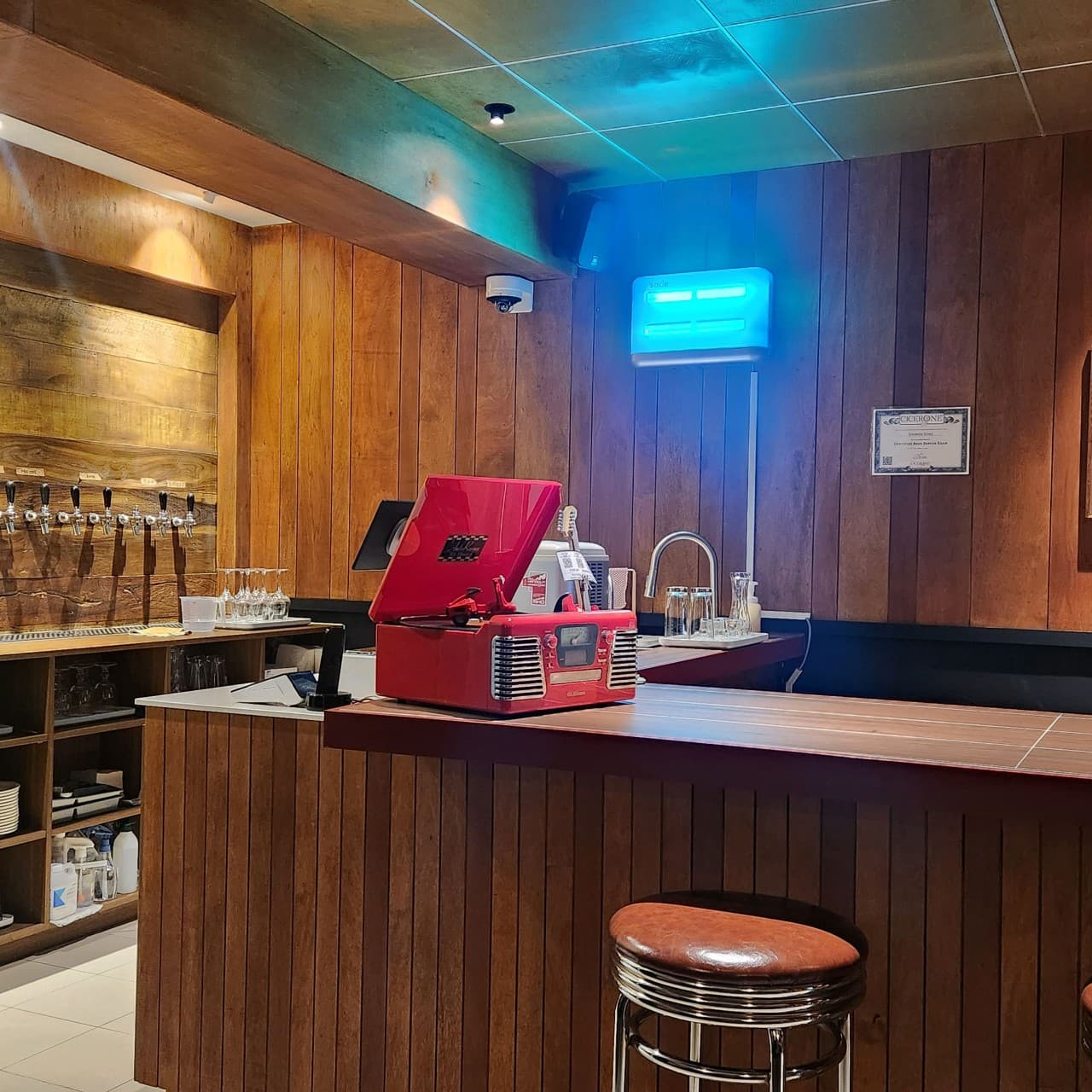 부산광역시 중구 마이행아웃 맥주 호프 - 원목 인테리어 다찌석 위 빨간 레코드 플레이어와 벽면 맥주 탭이 설치된 1인 혼술 공간