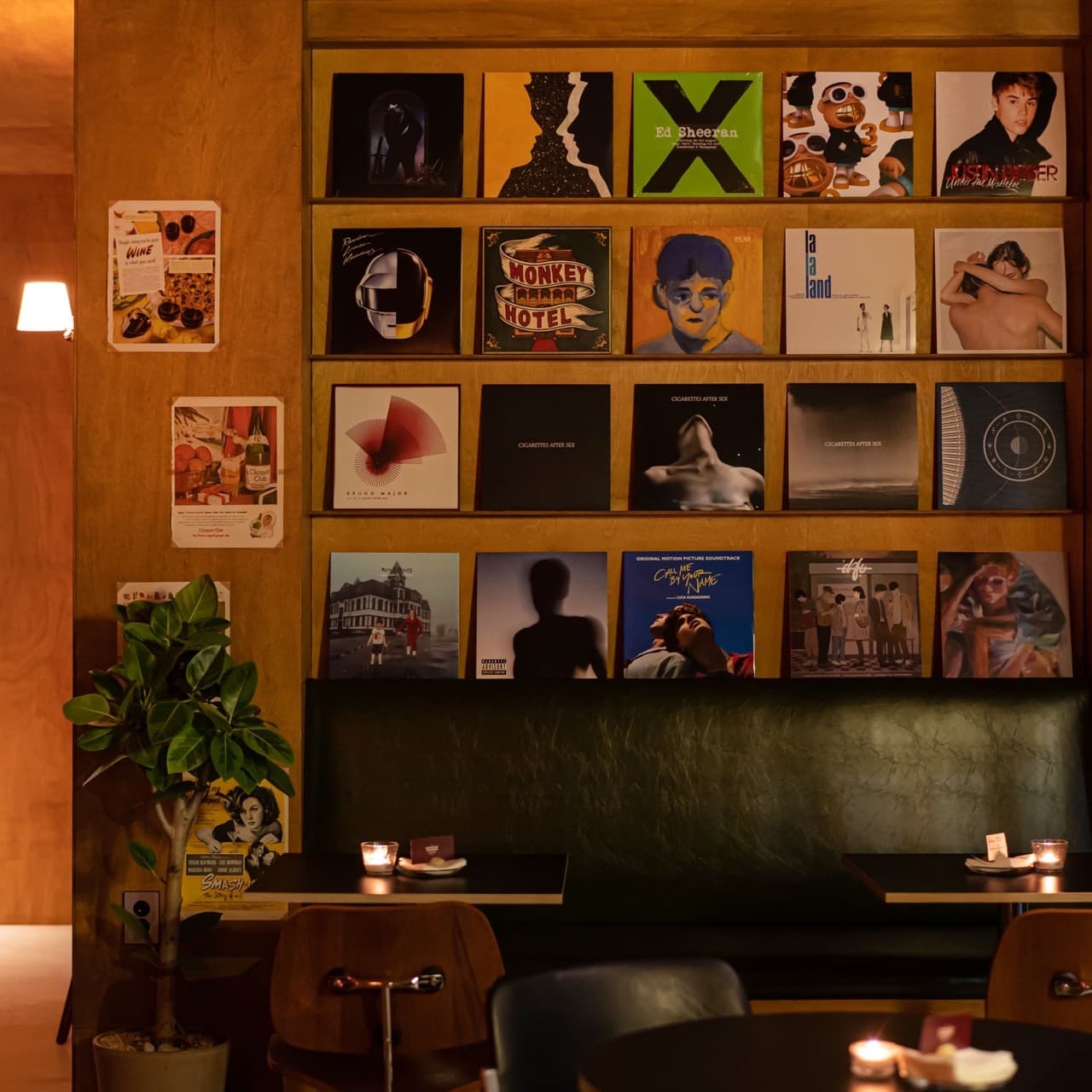 경상남도 진주시 요리주점 굿데이구디스 진주가좌본점. LP 레코드판 벽면과 촛불이 켜진 1인 테이블. 주황색 조명 아래 혼술 가능한 가죽 소파 좌석과 내부 전경.