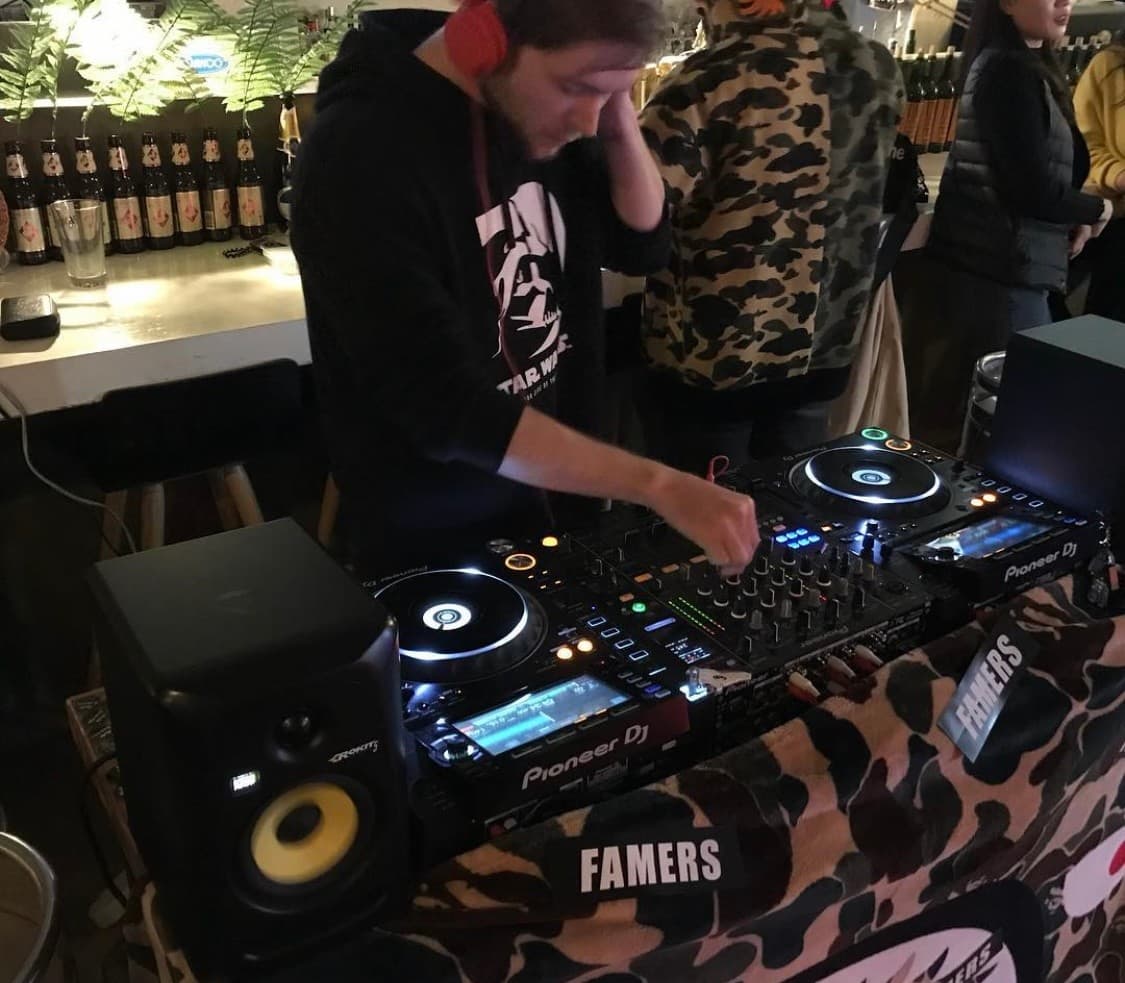 경상남도 진주시 파머스 맥주 호프의 조명 아래 DJ 부스와 맥주병이 진열된 다찌석. 혼술 가능한 1인 카운터석과 음악 장비가 배치된 내부 전경.