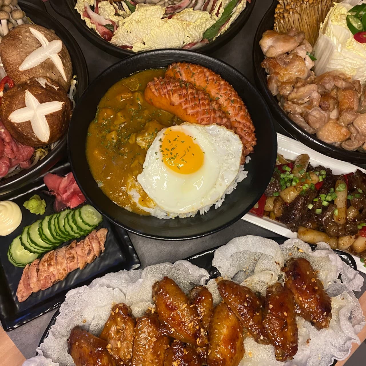 경상남도 진주시 이자카야 청월 진주평거점 진주 다찌석 위 노란 조명을 받는 카레와 명란구이, 닭날개 튀김. 1인 혼술에 적합한 메뉴 구성과 식재료의 질감.