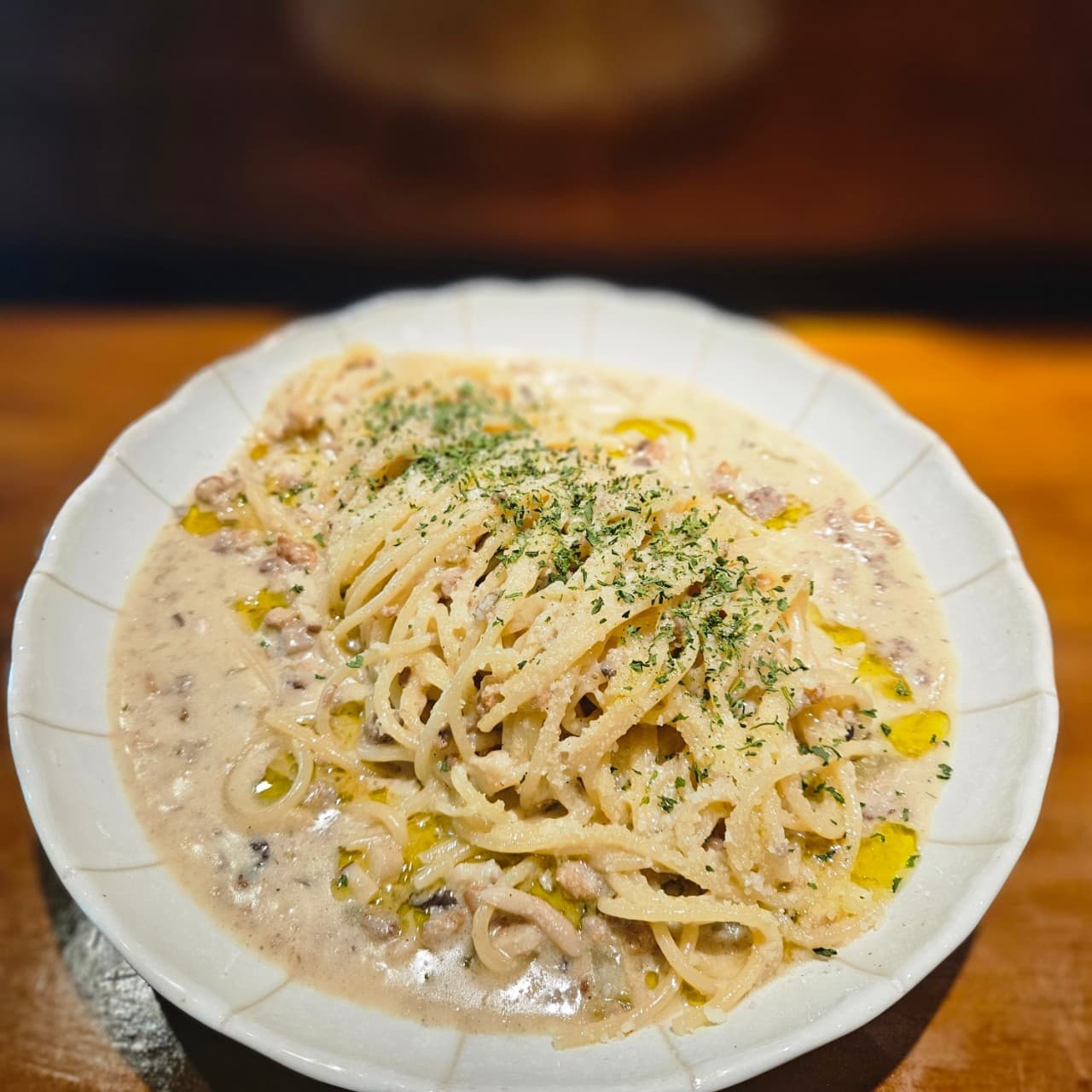 서울특별시 강남구 이자카야 고코 강남신논현점의 다찌석 조명 아래 놓인 크림 파스타. 꾸덕한 소스와 면의 질감이 돋보이는 1인 메뉴로 혼술 분위기를 연출함.