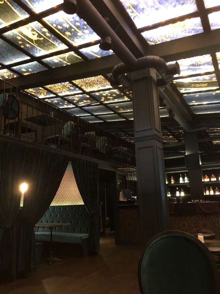 서울특별시 강남구 바 어글리 강남 - 별자리 천장 조명 아래 벨벳 소재 1인 커튼석과 다찌석이 배치된 혼술 공간