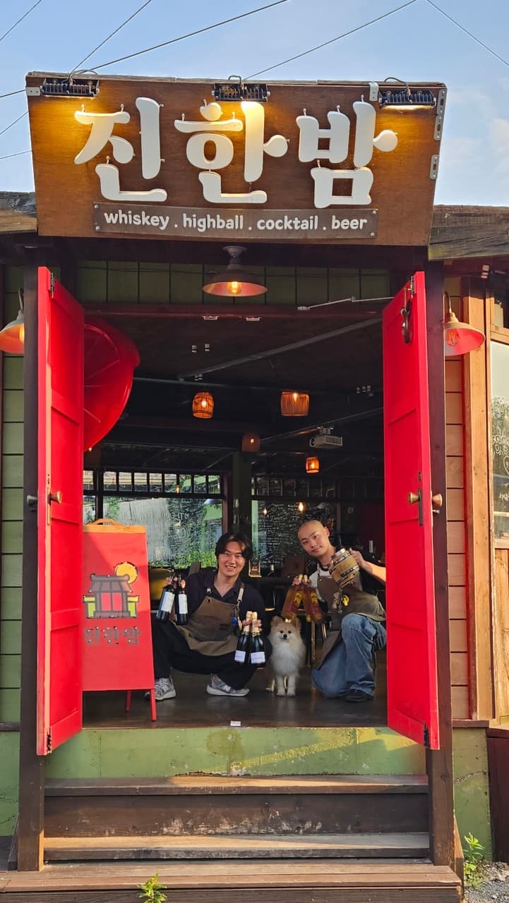 경상북도 경주시 진한밤 경주 바(Bar) 입구 붉은 문과 위스키 병을 든 직원들. 조명 아래 다찌석이 마련된 혼술 공간의 전경.