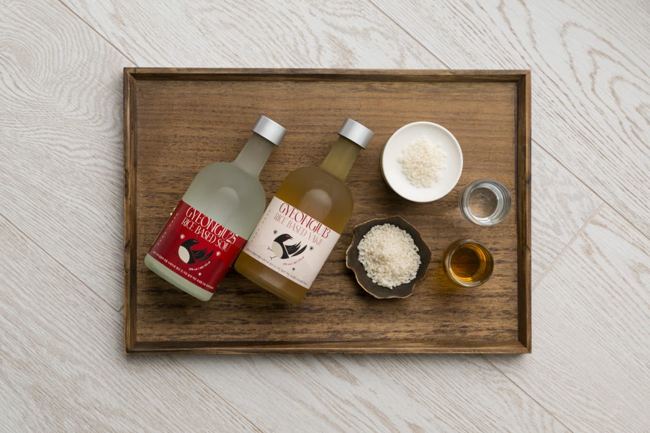 경상북도 경주시 요리주점 고도리 경주 1인 혼술 메뉴. 나무 쟁반 위 쌀로 빚은 전통주 두 병과 쌀알이 담긴 작은 그릇, 투명한 전용 잔이 차려진 모습.