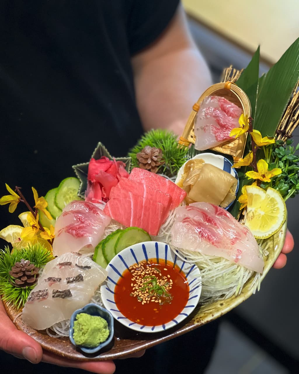 경상북도 경주시 이자카야 범굴 경주 - 다찌석 조명 아래 참치와 흰살생선이 담긴 1인 사시미 세트. 와사비, 초장, 레몬이 곁들여진 혼술 차림.