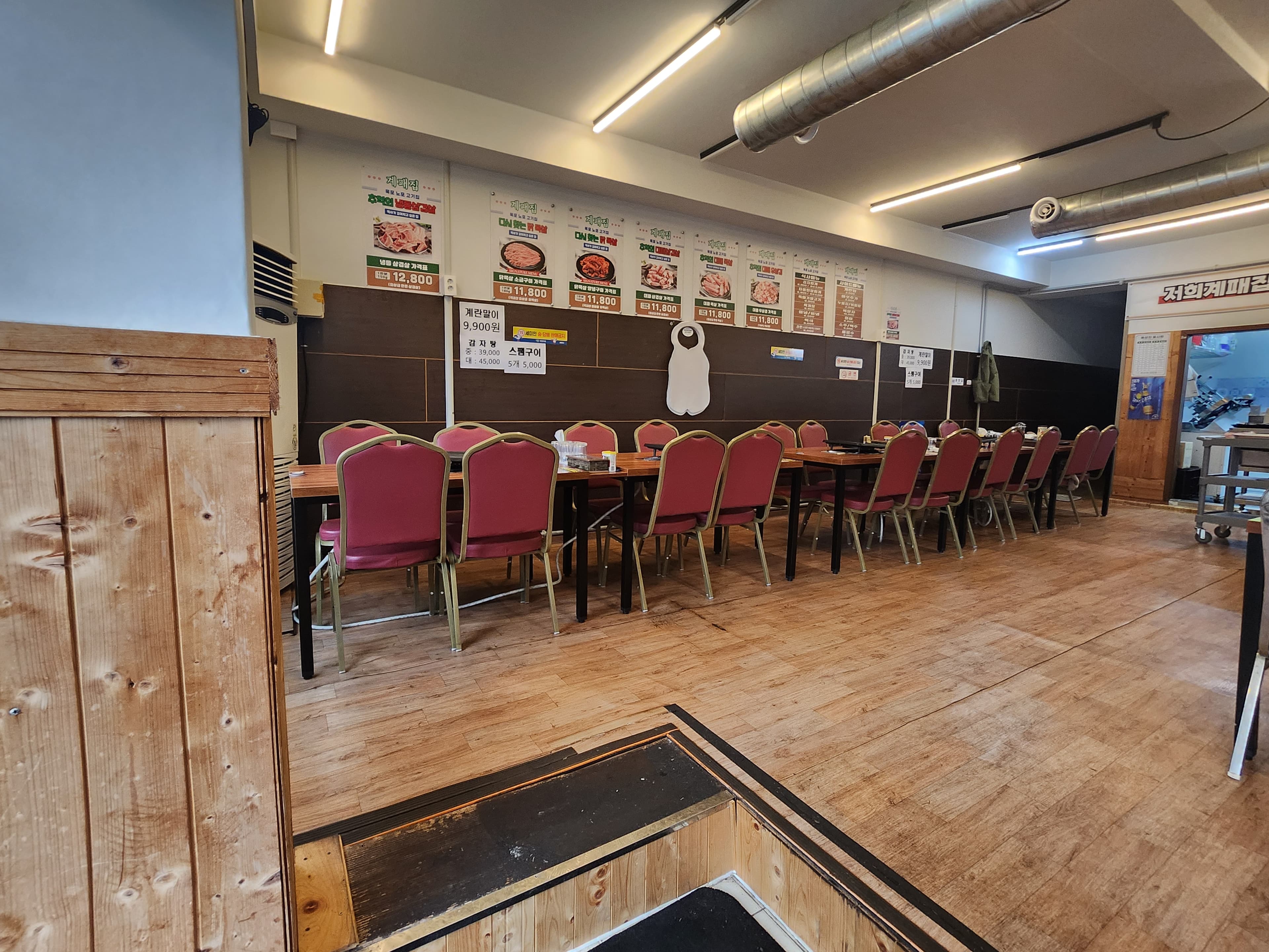 전라남도 목포시 혼밥 목포 계패집 - 밝은 조명 아래 긴 테이블과 붉은색 좌석이 배치된 기타 음식점 내부