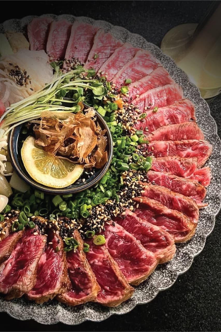 대구광역시 달서구 대담히 신월성점 대구 이자카야 다찌석 조명 아래 차려진 1인 소고기 타다끼. 선홍빛 육질 위로 쪽파와 가쓰오부시가 듬뿍 올라간 혼술 차림.