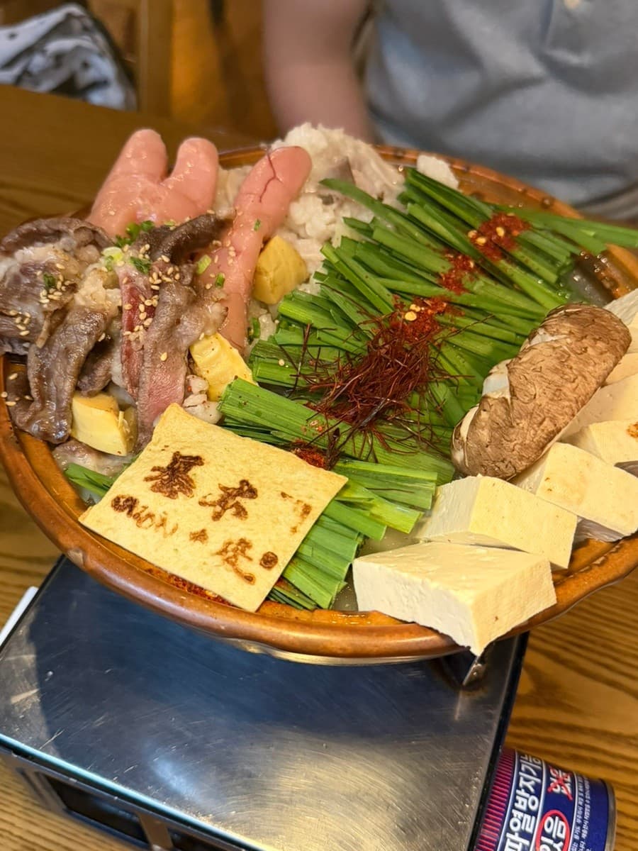 대구광역시 수성구 오호리준 범어본사직영점 대구 이자카야 다찌석의 혼술. 명란과 차돌박이, 부추가 담긴 모츠나베가 가스 버너 위 조명 아래 차려진 상황.