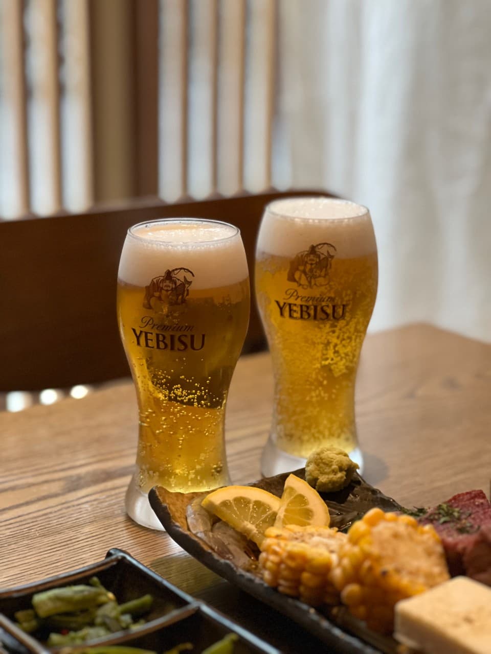 대구광역시 수성구 오호리준 범어본사직영점 대구 이자카야 다찌석 위 에비스 생맥주와 구운 옥수수. 노란 조명 아래 1인 혼술 상황을 묘사한 주류와 안주의 질감이 강조된 구성.