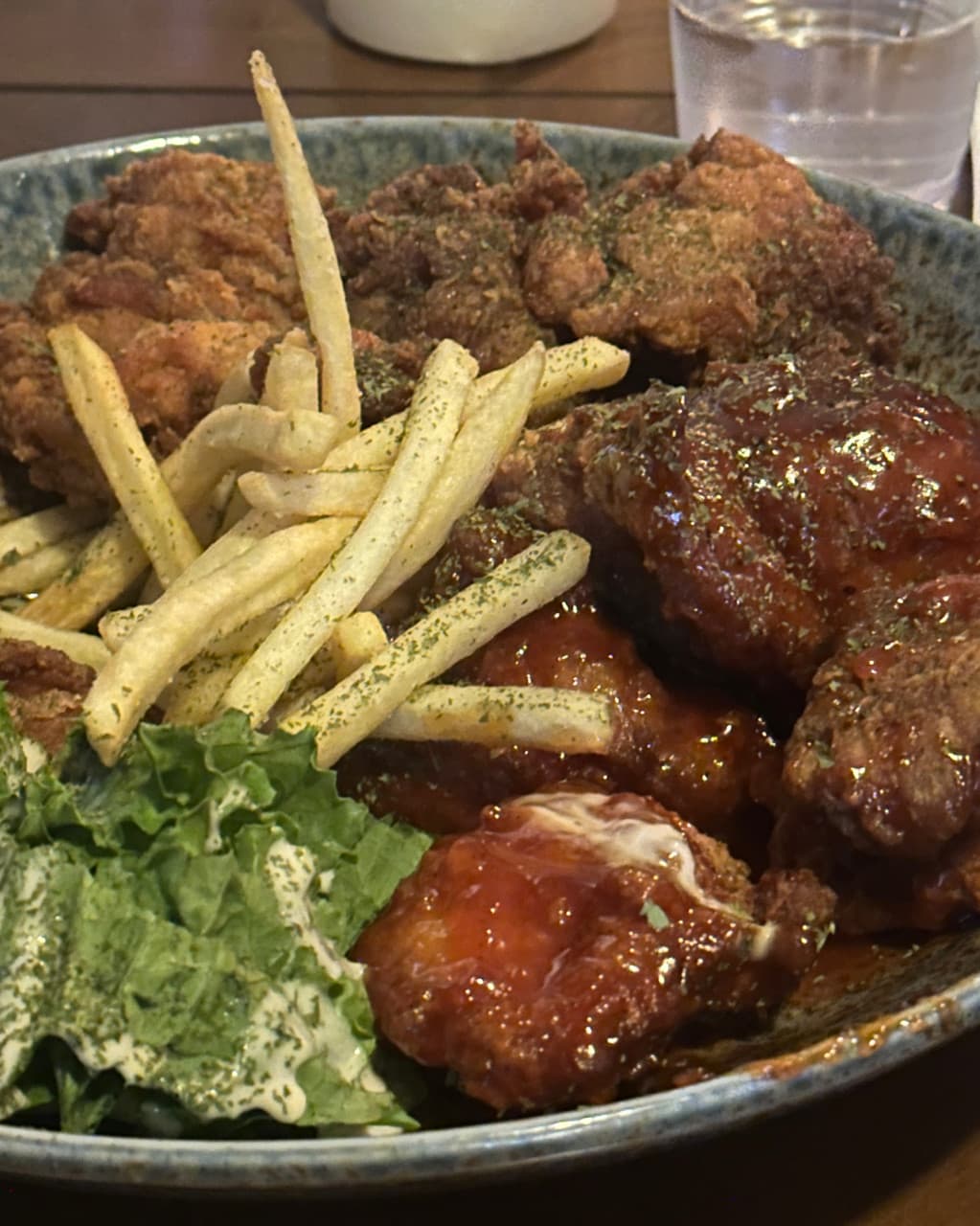 대구광역시 중구 헬로외국포차 대구 맥주 호프 다찌석에 차려진 혼술 안주. 바삭한 튀김옷의 후라이드와 양념 치킨, 감자튀김이 조명 아래 접시에 담긴 모습.
