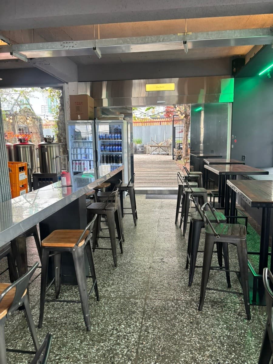 전남광주통합특별시 순천시 순천양조장 맥주 호프 - 초록색 네온 조명 아래 긴 카운터 다찌석과 높은 의자가 배치된 1인 혼술 공간 및 실내 양조 탱크