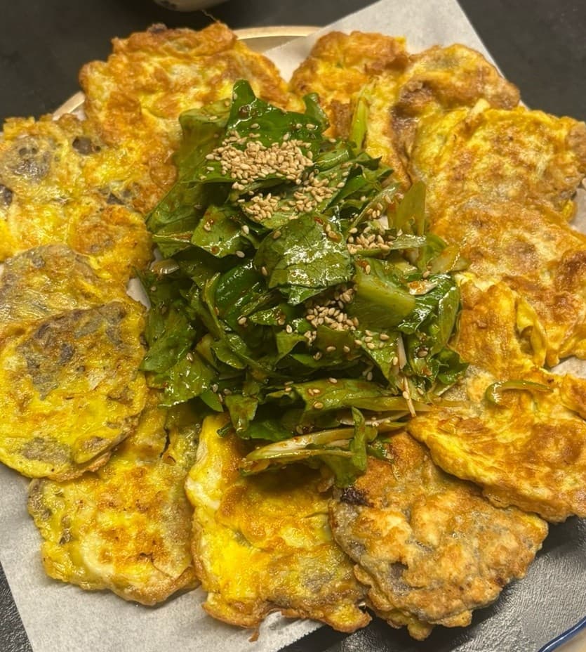 전남광주통합특별시 순천시 동선주막 순천 다찌석 조명 아래 놓인 노릇한 육전과 채소 무침. 1인 혼술에 적합한 기타 주점의 안주 구성과 질감.