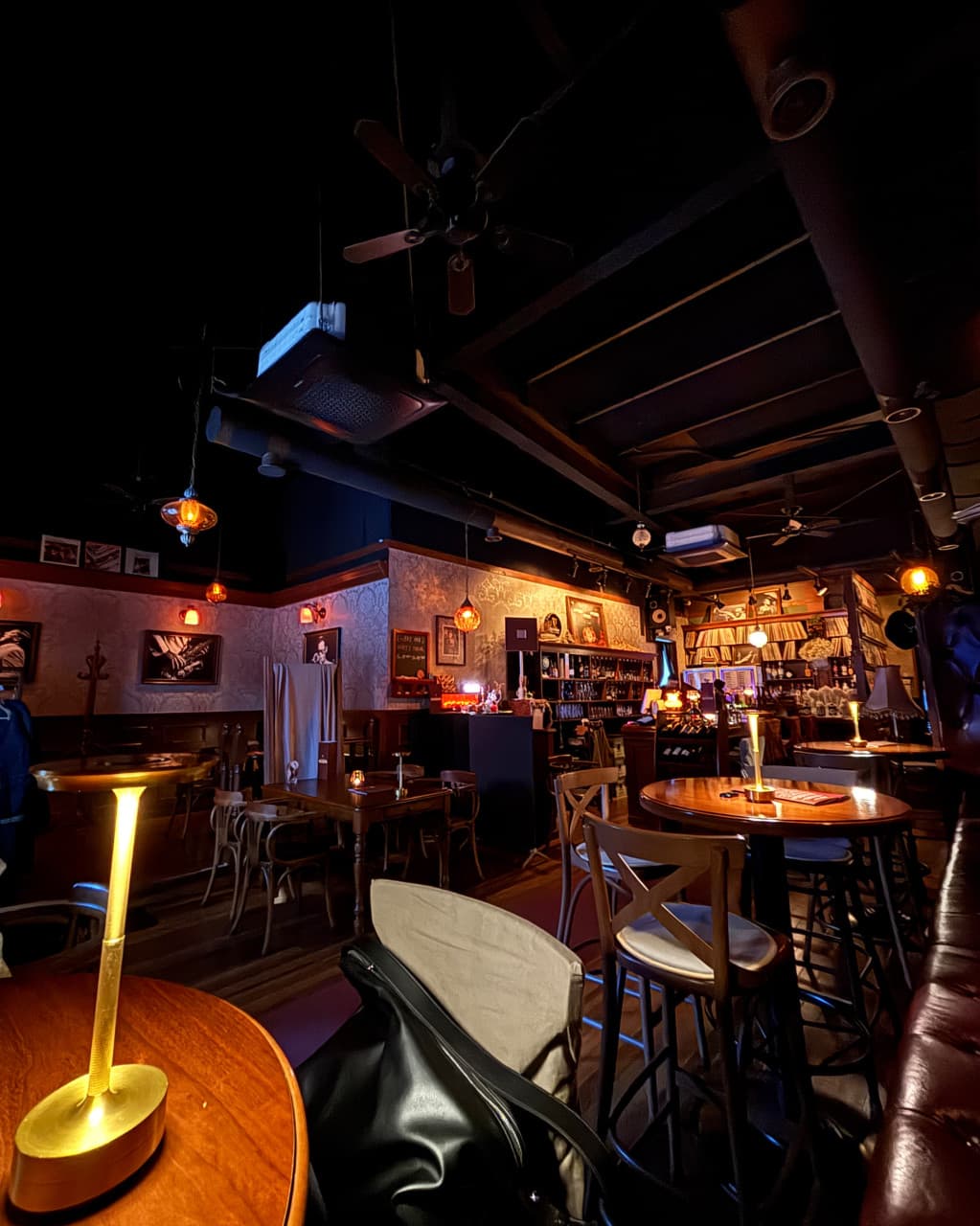 전남광주통합특별시 순천시 디들리밥 순천 오천점 바(Bar) - 노란 조명의 원형 목재 테이블과 레코드가 진열된 바 카운터 중심의 혼술 공간