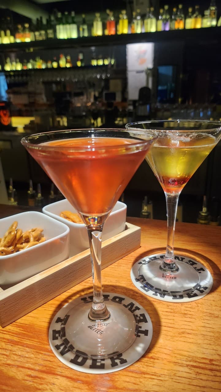 전남광주통합특별시 순천시 텐더 전남 바(Bar) - 조명 아래 나무 다찌석에 놓인 두 잔의 칵테일과 프레첼이 있는 혼술 상황