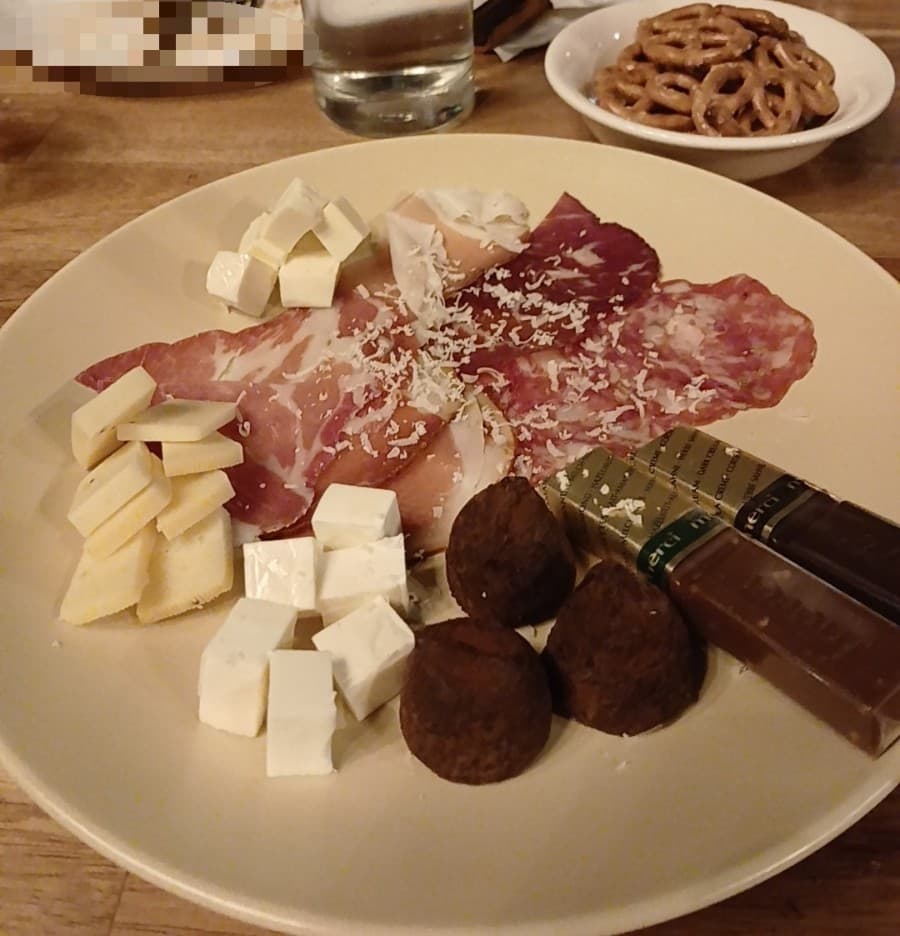 전남광주통합특별시 순천시 혼술 바(Bar) 펜스터 전남 - 조명 아래 다찌석에 차려진 햄, 치즈, 초콜릿 구성의 1인 안주 플레이트와 프레첼