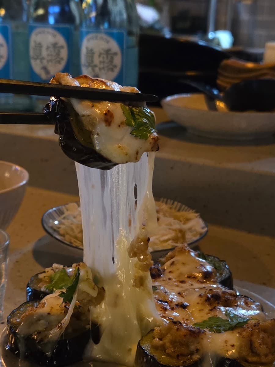 전남광주통합특별시 순천시 이자카야 무카 전남 다찌석. 젓가락으로 들어 올려 길게 늘어나는 치즈의 질감과 조명 아래 차려진 1인 혼술 메뉴.