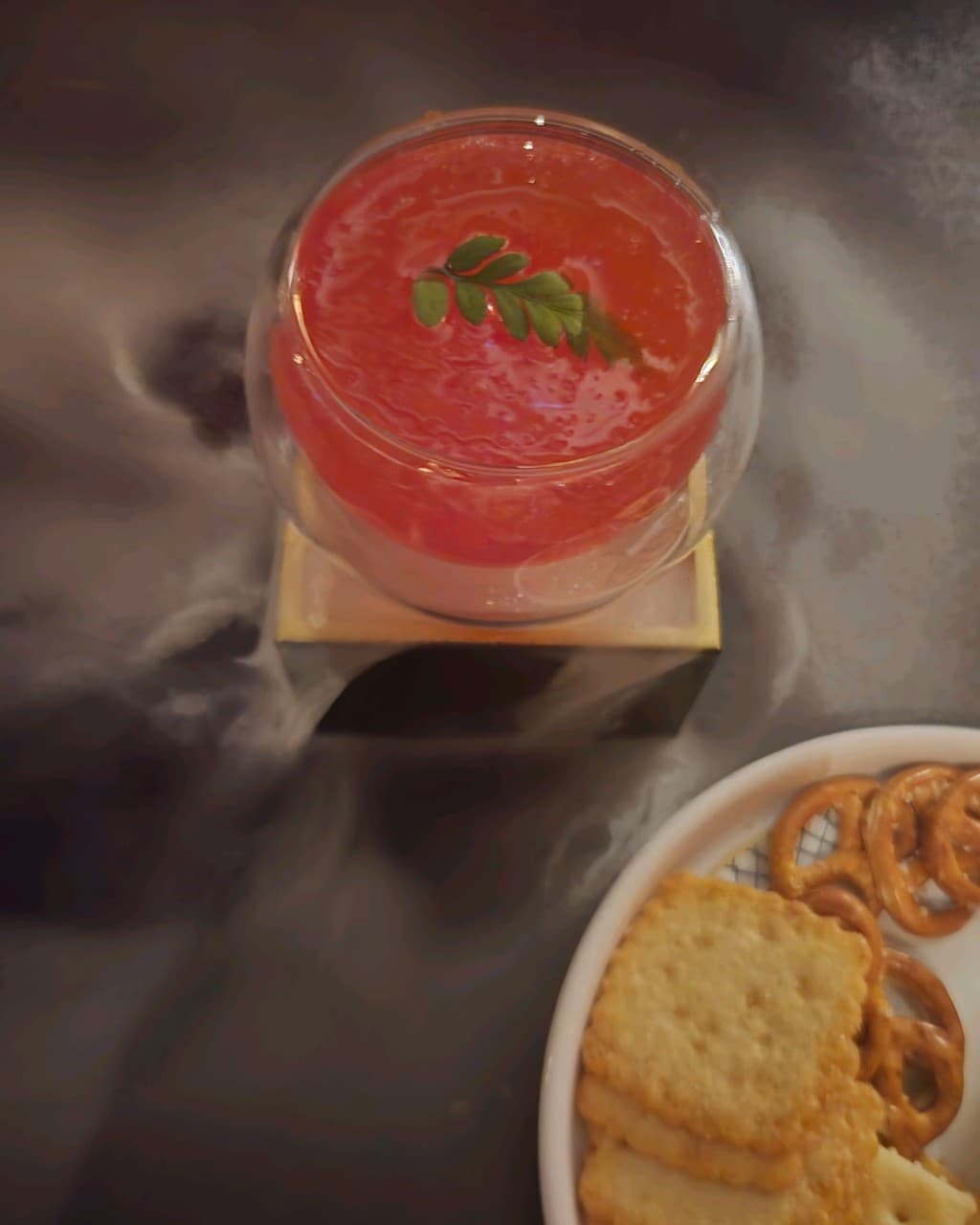 전남광주통합특별시 순천시 더클래식 전남 바(Bar) 혼술 상황. 낮은 조명 속 드라이아이스 연기가 흐르는 붉은 칵테일과 크래커가 놓인 1인 다찌석 풍경.