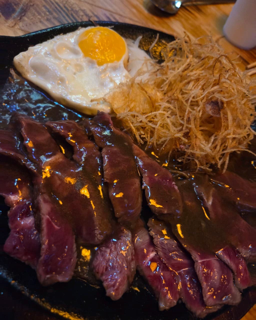인천광역시 부평구 이자카야 코코스키 부평점 인천 다찌석 조명 아래 놓인 혼술 메뉴 소고기 스테이크와 계란후라이, 튀김 가니쉬.