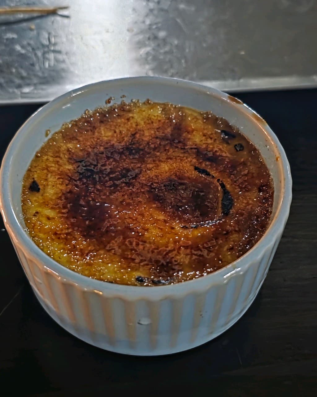 세종특별자치시 조치원읍 바 비버 세종 다찌석에서 즐기는 혼술. 어두운 조명 아래 설탕을 토치로 구워낸 크림브륄레의 바삭한 질감과 1인용 테이블 구성.