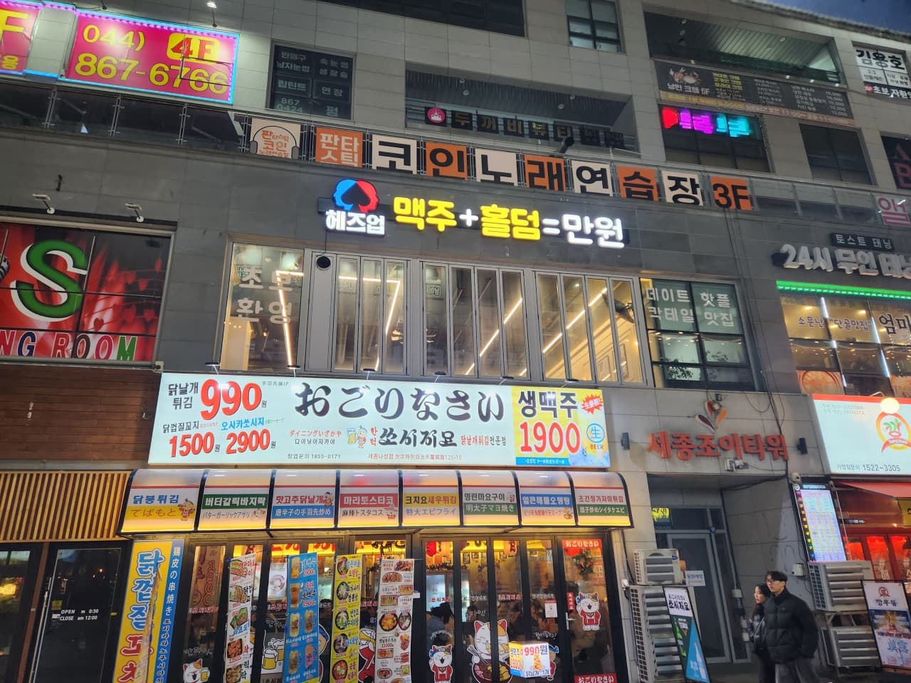 세종특별자치시 나성로 헤즈업 세종나성점 맥주 호프 매장. 밝은 간판 조명과 창가 1인석이 배치된 외관으로 혼술과 시원한 맥주를 즐기는 분위기를 보여줌.