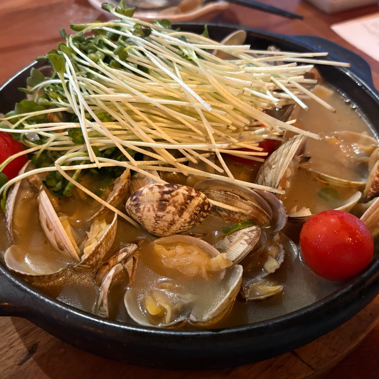 세종특별자치시 나성북1로 이자카야탕 세종점 다찌석 조명 아래 놓인 바지락 술찜. 무순과 토마토가 담긴 검은색 냄비의 1인 혼술 차림과 이자카야 분위기