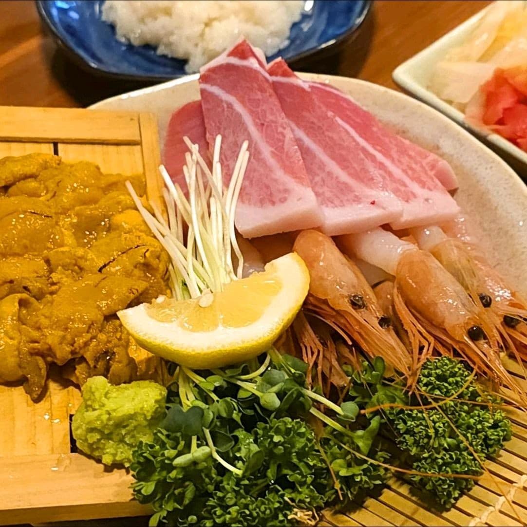 세종특별자치시 보듬3로 이자카야혼마 세종 이자카야 다찌석 혼술. 조명 아래 성게알과 참치, 단새우의 선명한 질감이 돋보이는 1인 메뉴가 나무 테이블 위에 차려짐.
