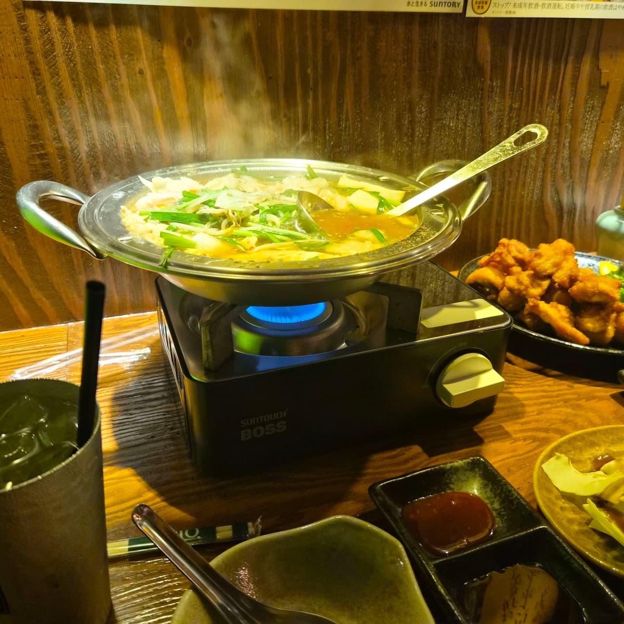 대전광역시 서구 이자카야 마포십번 갈마본점 다찌석 혼술. 가스버너 위 김이 나는 전골과 바삭한 튀김, 하이볼이 노란 조명 아래 나무 테이블에 놓인 모습.