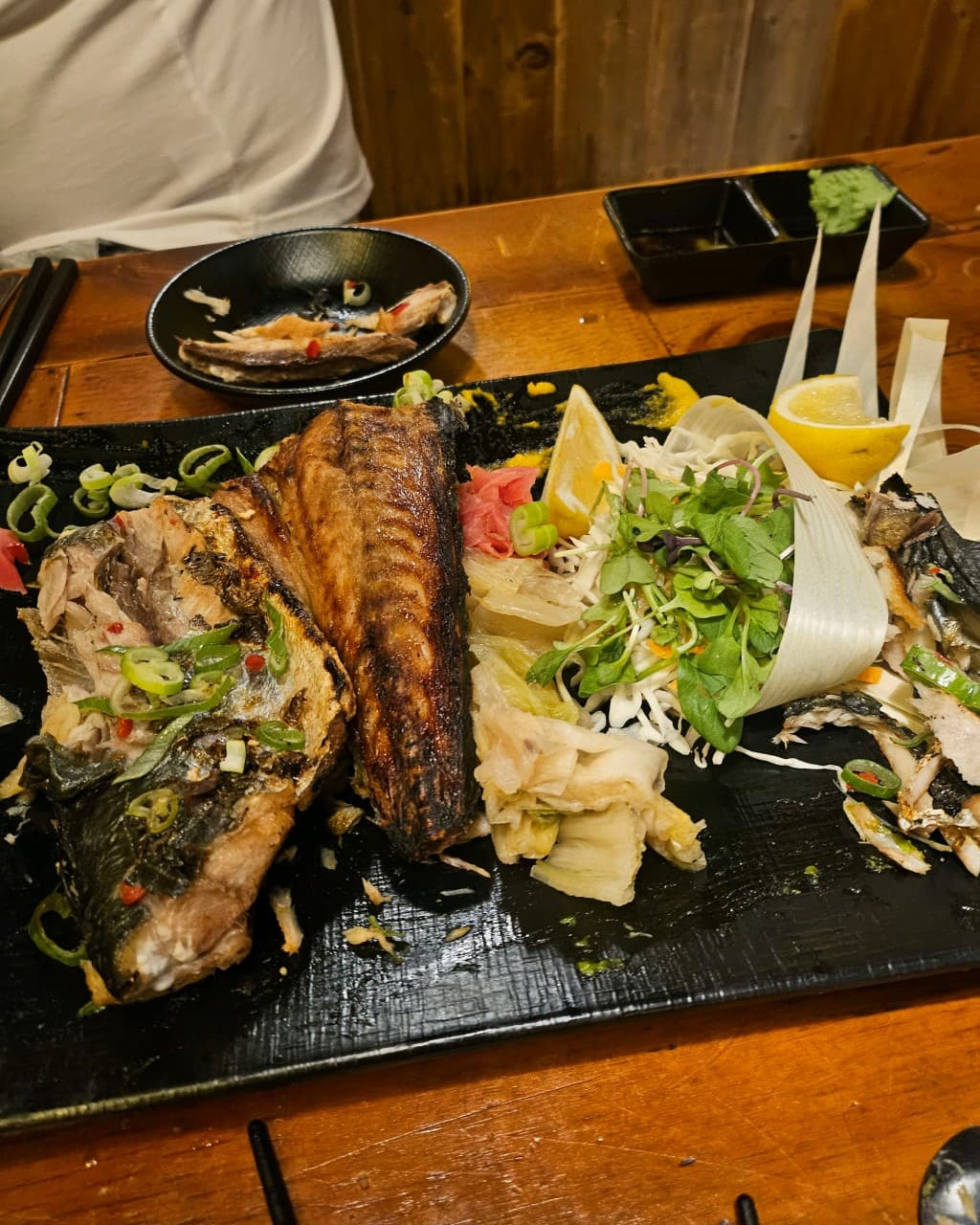 대전광역시 중구 해마직화구이 대전 이자카야 나무 테이블 위 노란 조명을 받은 생선구이와 샐러드. 1인 혼술 메뉴의 바삭한 질감이 돋보이는 차림새.