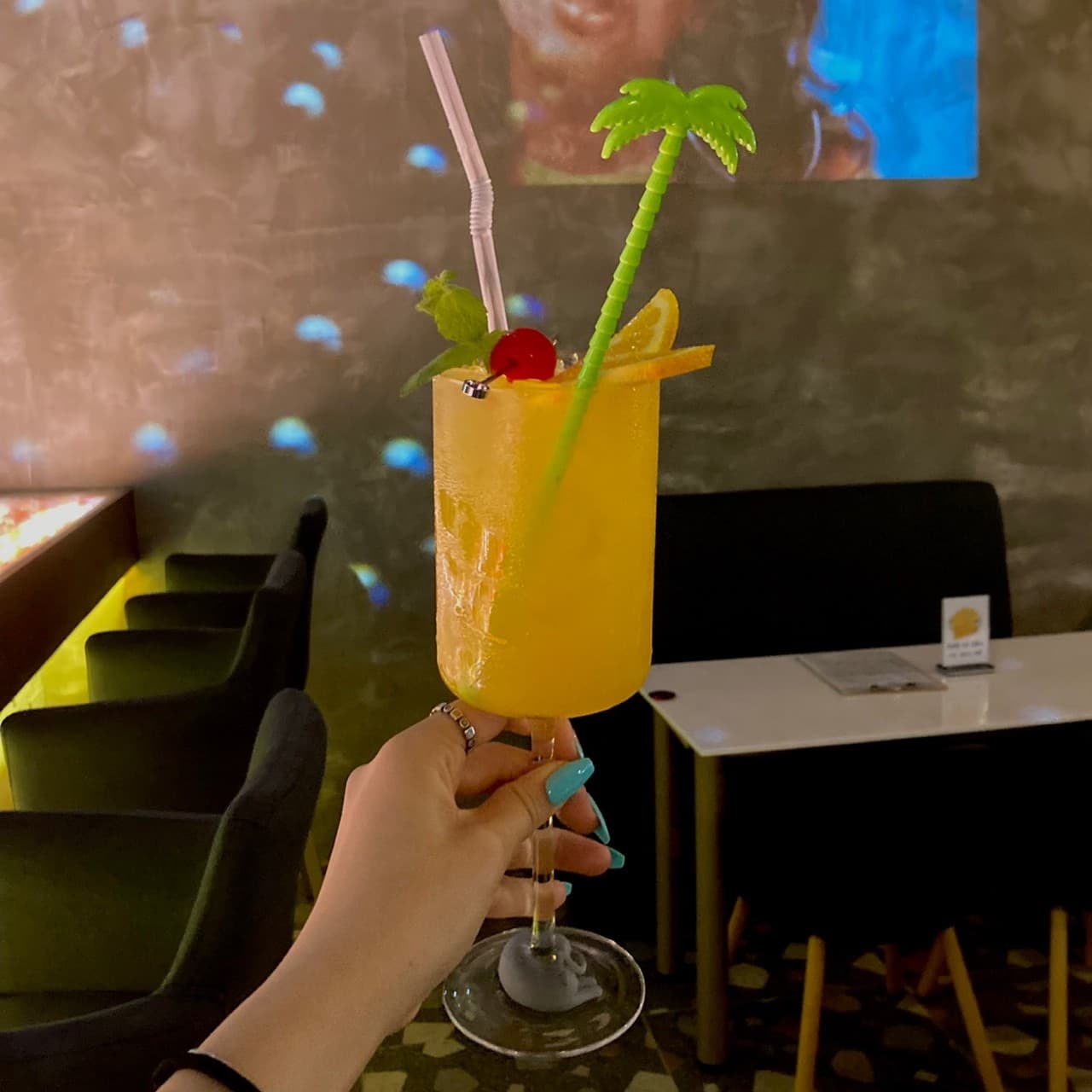 인천광역시 서해구 러시안블루 인천 바(Bar)에서 야자수 장식 칵테일을 든 모습. 어두운 조명 아래 1인 다찌석과 테이블이 배치된 실내에서 혼술을 즐기는 상황.