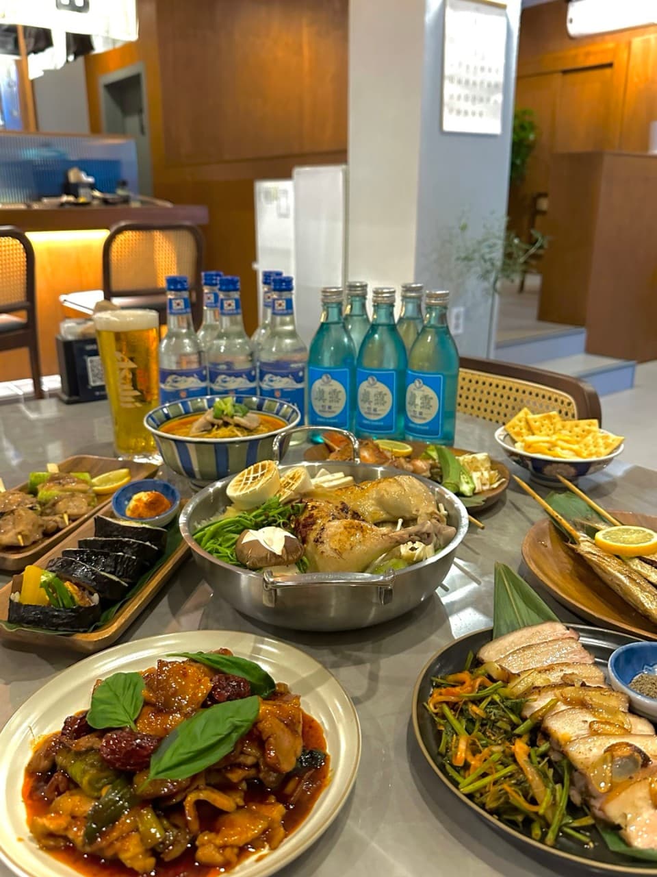 인천광역시 부평구 요리주점 일향 인천 다찌석 조명 아래 놓인 닭전골과 소주. 1인 혼술 상황에 맞춰 차려진 안주들의 질감과 나무 소재의 내부 공간.