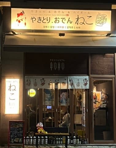 인천광역시 미추홀구 혼술 이자카야 네코 미추홀본점 인천 - 밝은 조명 아래 사케 병이 진열된 외관과 유리창 너머 다찌석에 앉은 1인 손님들의 모습