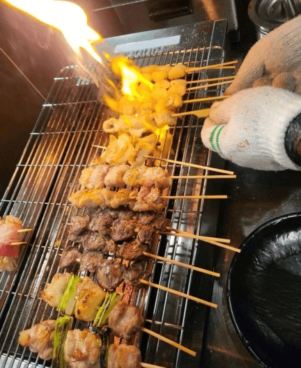 인천광역시 미추홀구 네코 미추홀본점 인천 이자카야 혼술 다찌석. 직화 불길 위에서 노릇하게 익어가는 다양한 꼬치구이의 육질과 연기가 어우러진 조리 현장.