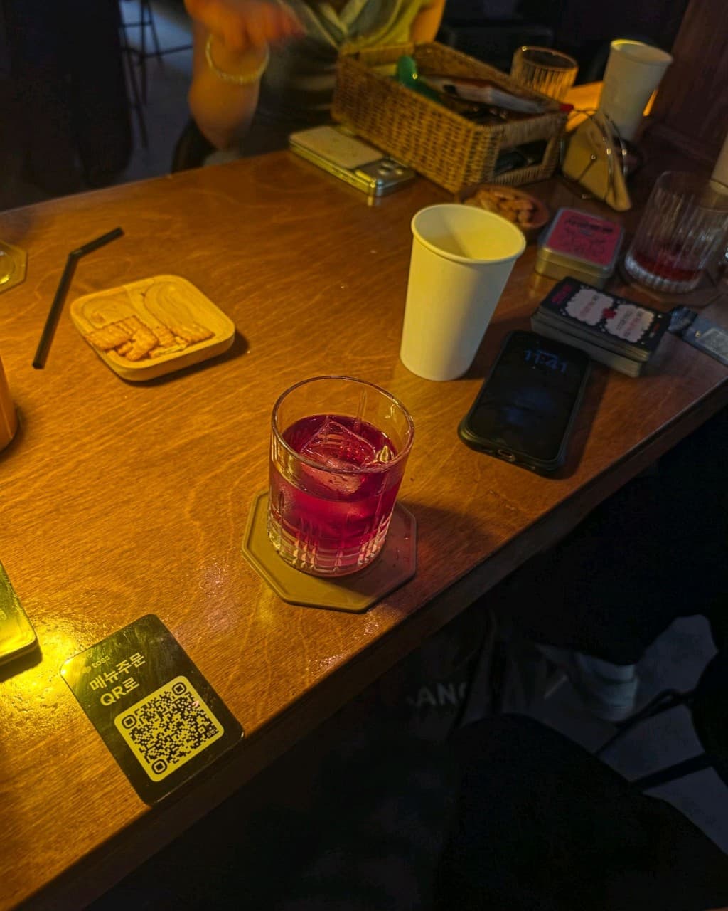 인천광역시 부평구 혼술바 고도 부평점 인천 바(Bar) 노란 조명 아래 다찌석에서 즐기는 붉은 칵테일과 크래커. QR 주문 시스템이 있는 나무 테이블의 1인 혼술 상황.