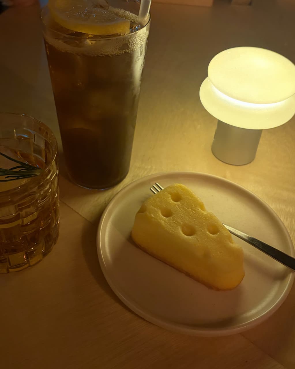 인천광역시 부평구 헤르츠 혼술바 부평점 인천 바(Bar) 다찌석 노란 조명 아래 레몬 하이볼과 치즈 케이크가 차려진 1인 혼술 상황. 메뉴의 질감과 테이블 구성을 보여줌.