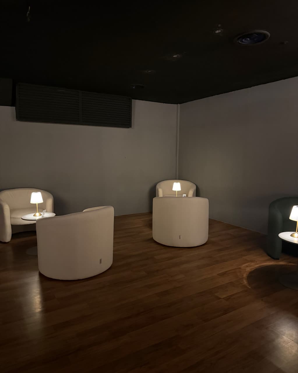 인천광역시 남동구 애프터퇴근 혼술바 구월점 인천 바(Bar). 우드 바닥 위 1인용 소파와 개별 스탠드 조명이 배치된 독립적인 좌석 공간에서 혼자 술을 마시는 상황.