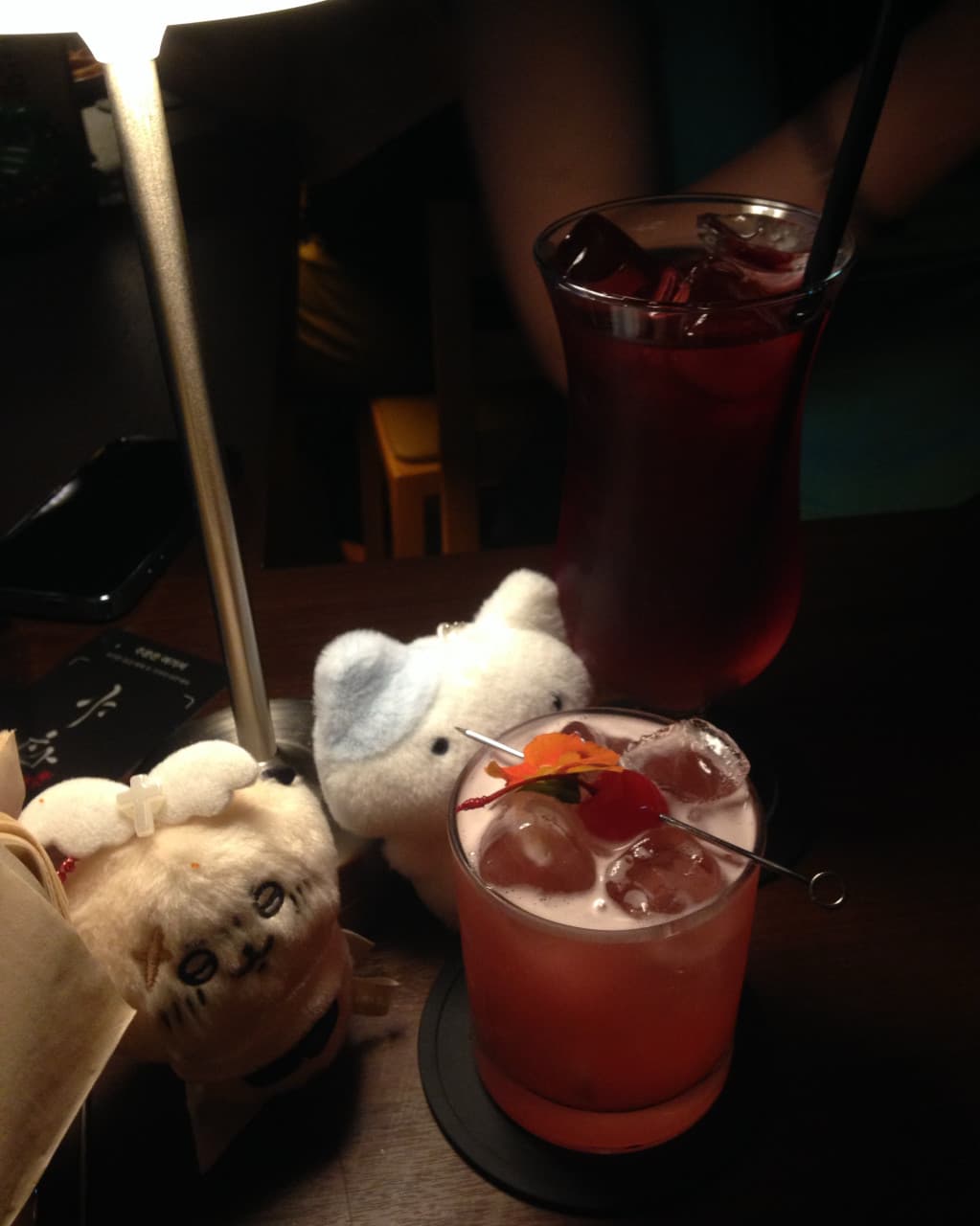전남광주통합특별시 서구 야화 혼술바 광주상무점 전남 바(Bar)의 집중 조명 아래 체리 장식 칵테일과 캐릭터 인형. 다찌석에서 1인 혼술 하며 마시는 음료 속 각얼음의 투명한 질감.
