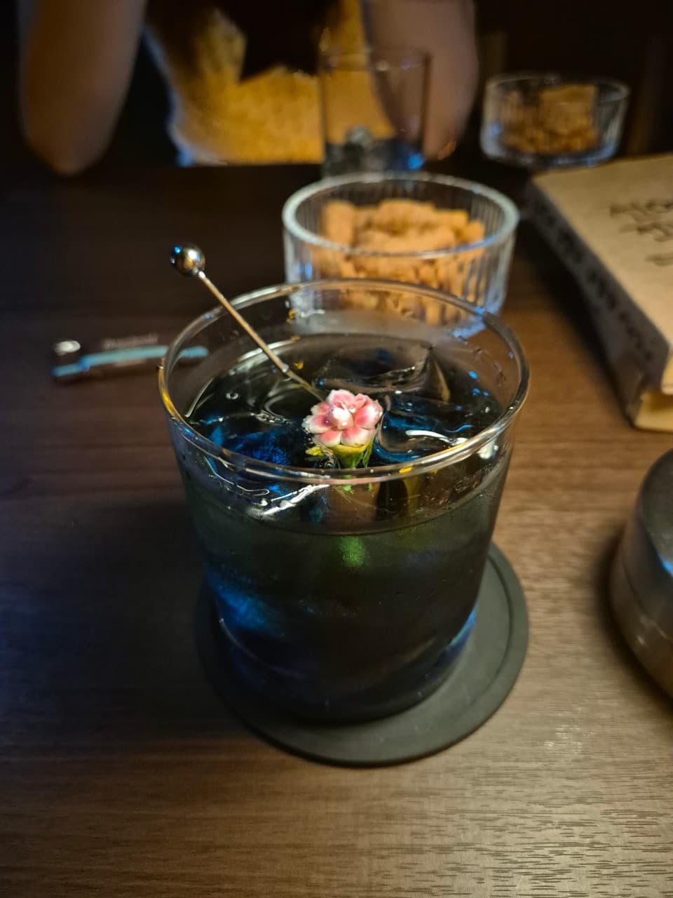 전남광주통합특별시 서구 야화 혼술바 광주상무점 전남 바(Bar) 다찌석에서 어두운 조명 아래 꽃 장식 칵테일과 간단한 안주를 즐기는 1인 혼술 상황