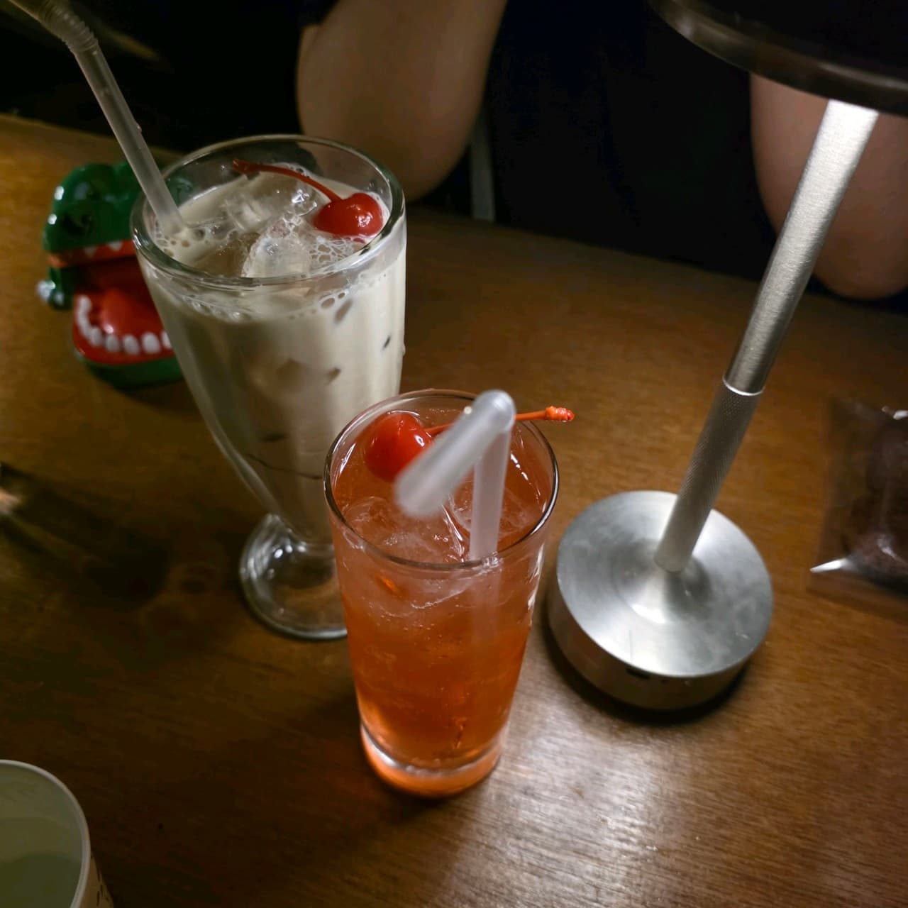 경상북도 경주시 제주아홉 혼술바 경주황리단길점 경북 바(Bar)의 조명 아래 체리가 놓인 음료와 1인 다찌석. 나무 테이블에서 혼술을 즐기는 상황