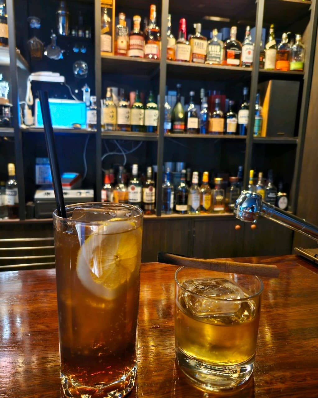 경상북도 안동시 레옹 정하점 경북 바(Bar) 다찌석에 놓인 레몬 하이볼과 위스키 온더락. 진열된 양주병을 배경으로 우드 테이블에서 즐기는 1인 혼술 상황