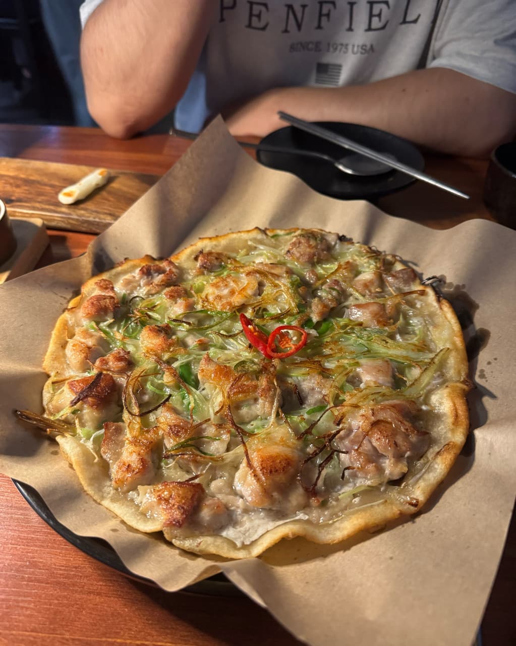 경기도 수원시 매산약수터 수원역본점 경기 요리주점의 핀 조명 아래 1인 다찌석 혼술. 노릇하게 구워진 고기 고명과 파가 어우러진 전 요리가 나무 테이블에 차려진 상황.
