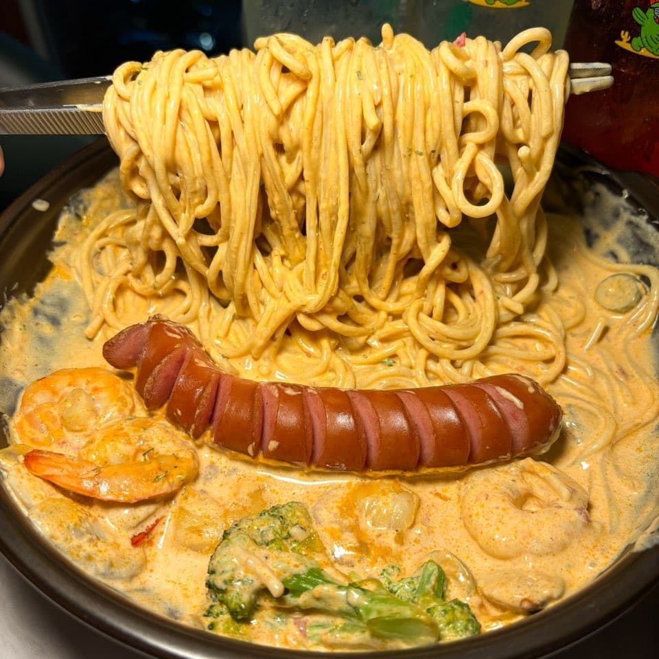 경기도 파주시 요리주점 피맥당x레츠펍 파주야당본점 경기 다찌석 혼술. 집게로 들어 올린 꾸덕한 파스타와 소시지, 새우가 담긴 1인 메뉴.