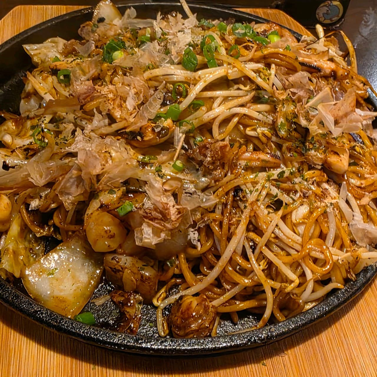 경기도 부천시 철판오사카야 부천점 경기 이자카야. 1인 다찌석 위 가다랑어포가 올라간 야키소바와 숙주가 담긴 철판 요리. 은은한 조명 아래 홀로 즐기는 혼술 상황.