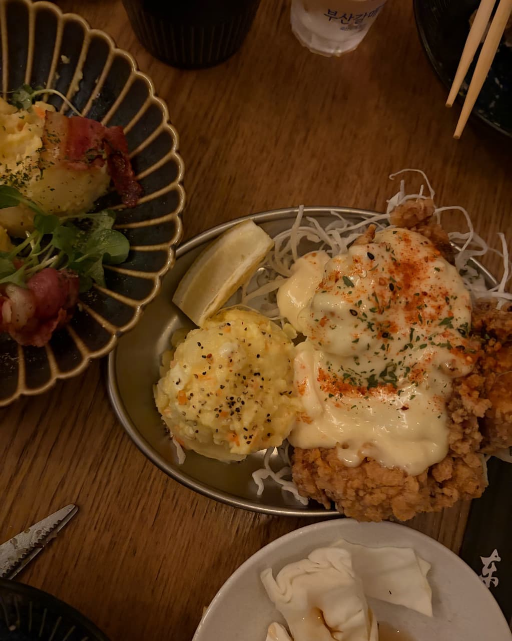 부산광역시 부산진구 요리주점 앙요 전포본점 부산 다찌석 혼술. 어두운 조명 아래 타르타르 소스를 얹은 바삭한 가라아게와 포슬포슬한 감자샐러드 구성.